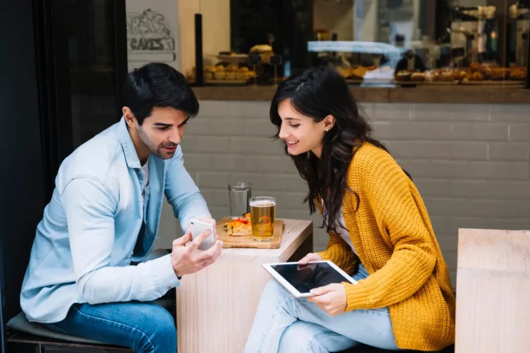 couple-cafe-looking-smartphone-screen