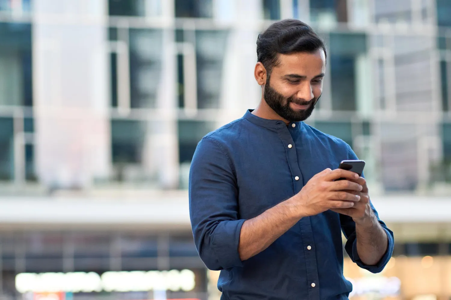 indian-business-man-using-smartphone-standing-urban-city-street-outdoors