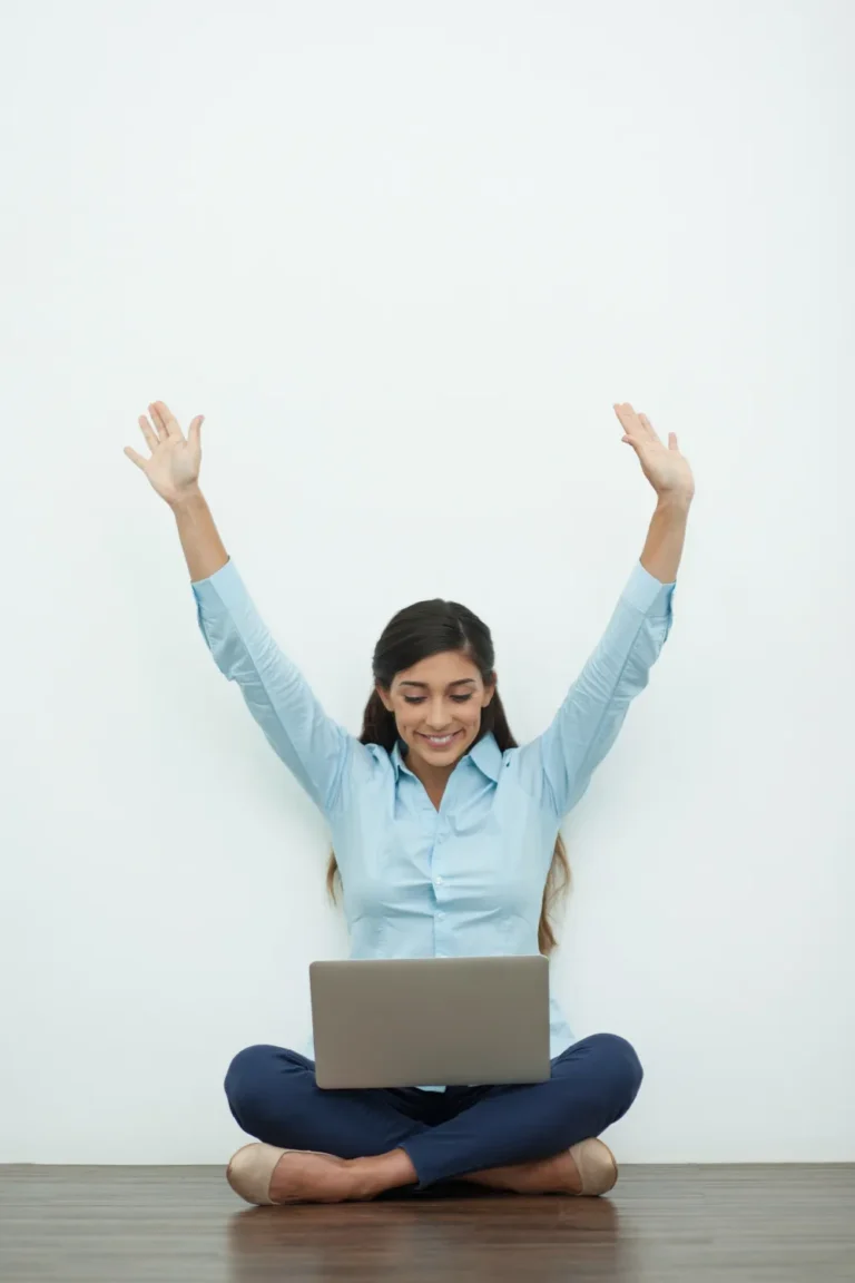 joyful-young-woman-working-laptop-floor