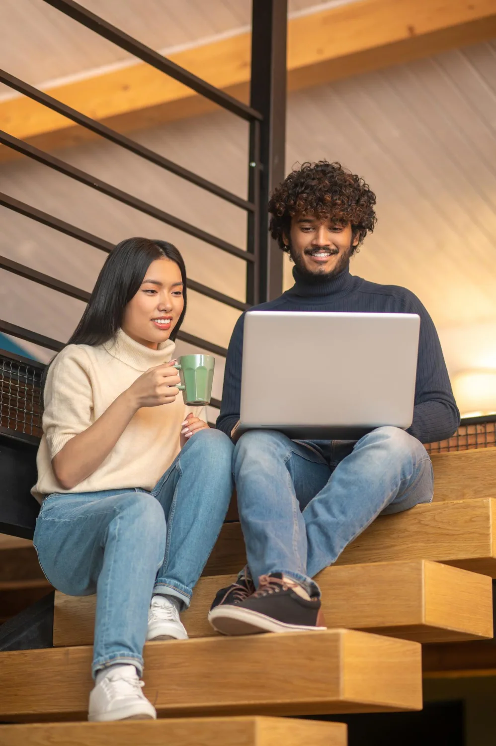 man-woman-looking-laptop-sitting-stairs