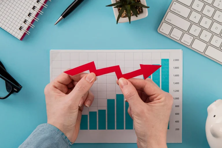 top-view-business-items-with-growth-chart-hands-holding-arrow